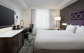 Delux king room with TV, desk, and natural light at Courtyard San Diego Downtown.