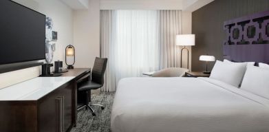 Delux king room with TV, desk, and natural light at Courtyard San Diego Downtown.