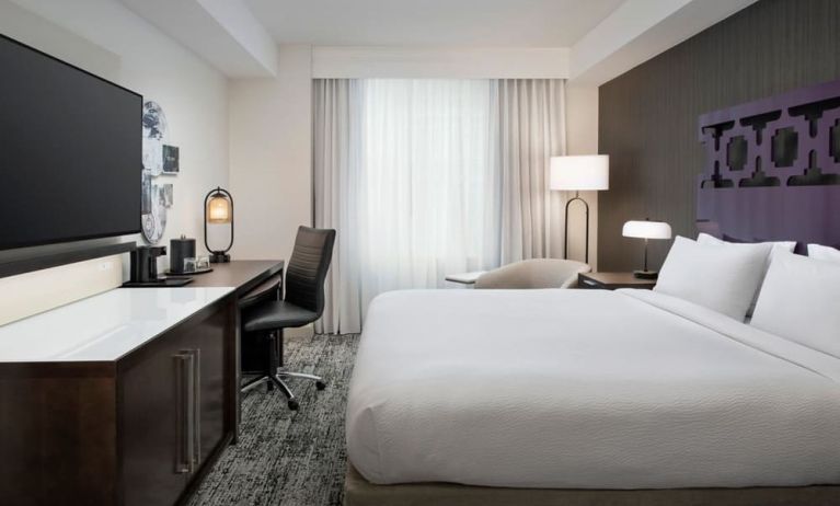 Delux king room with TV, desk, and natural light at Courtyard San Diego Downtown.