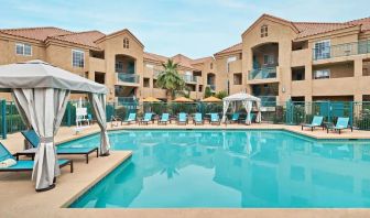 Lovely outdoor pool with cabanas and pool chairs at Hyatt House Scottsdale.