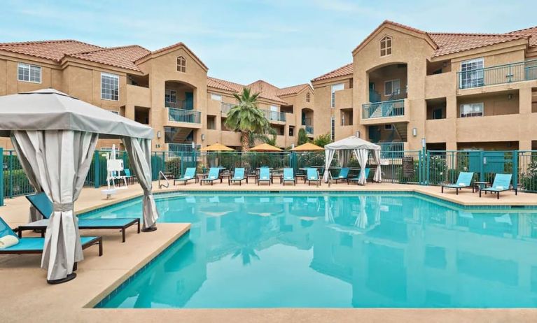 Lovely outdoor pool with cabanas and pool chairs at Hyatt House Scottsdale.