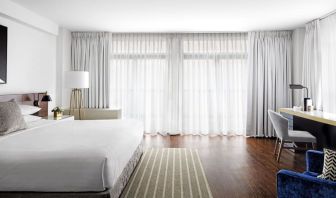 King bedroom with desk, chair, and natural light at St Gregory Hotel.