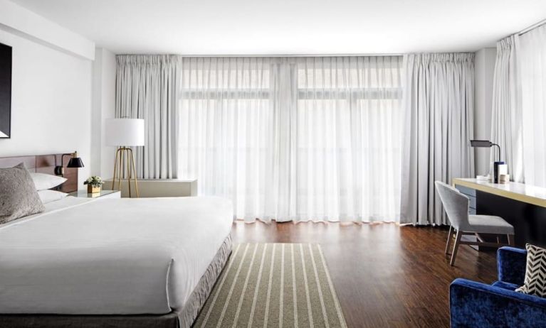 King bedroom with desk, chair, and natural light at St Gregory Hotel.