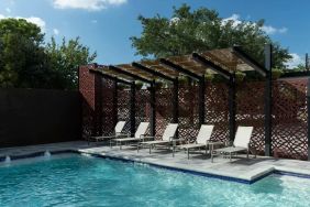 Stunning outdoor pool with pool chairs at Courtyard By Marriott Houston Heights/I-10.