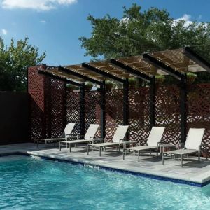 Stunning outdoor pool with pool chairs at Courtyard By Marriott Houston Heights/I-10.