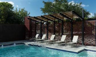 Stunning outdoor pool with pool chairs at Courtyard By Marriott Houston Heights/I-10.