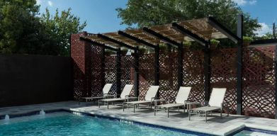 Stunning outdoor pool with pool chairs at Courtyard By Marriott Houston Heights/I-10.