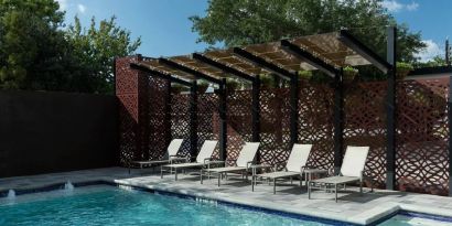 Stunning outdoor pool with pool chairs at Courtyard By Marriott Houston Heights/I-10.