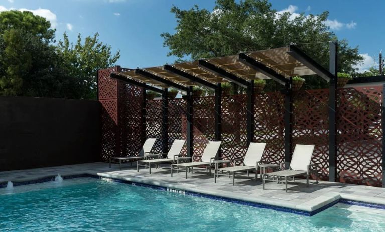 Stunning outdoor pool with pool chairs at Courtyard By Marriott Houston Heights/I-10.