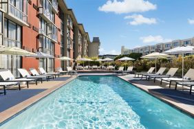 Stunning outdoor pool with sun beds and umbrellas at Hotel Caza.