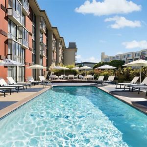 Stunning outdoor pool with sun beds and umbrellas at Hotel Caza.