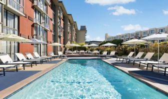 Stunning outdoor pool with sun beds and umbrellas at Hotel Caza.