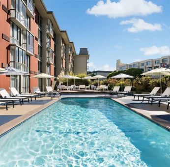 Stunning outdoor pool with sun beds and umbrellas at Hotel Caza.