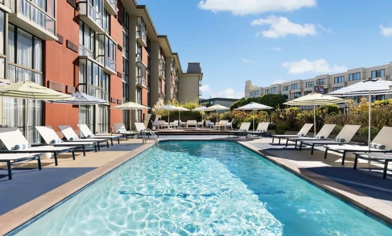 Stunning outdoor pool with sun beds and umbrellas at Hotel Caza.