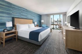 King bedroom with lots of natural light and work desk at Hotel Caza.