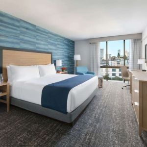 King bedroom with lots of natural light and work desk at Hotel Caza.