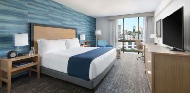 King bedroom with lots of natural light and work desk at Hotel Caza.