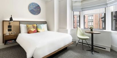 Delux king room with desk and chair at The James New York, NoMad.