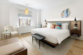 King bedroom with lounge area and natural light at The James New York, NoMad.