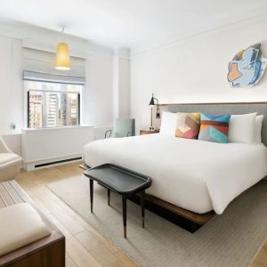 King bedroom with lounge area and natural light at The James New York, NoMad.