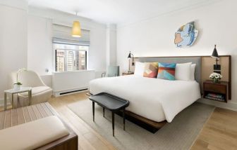 King bedroom with lounge area and natural light at The James New York, NoMad.