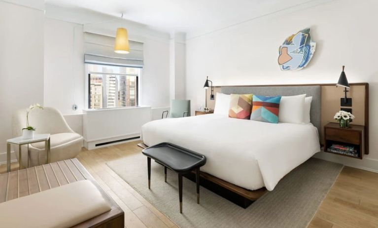 King bedroom with lounge area and natural light at The James New York, NoMad.