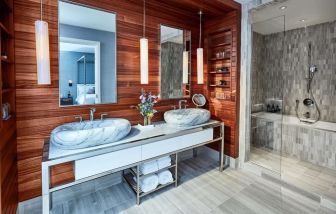 Private guest bathroom with shower and bath at The James New York, NoMad.