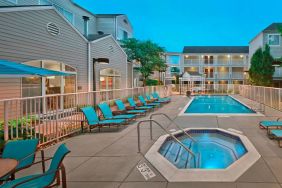 Outdoor pool with lounge chairs at Residence Inn Boston Tewksbury.
