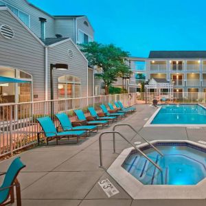 Outdoor pool with lounge chairs at Residence Inn Boston Tewksbury.
