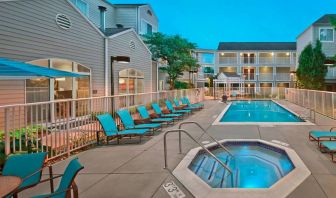 Outdoor pool with lounge chairs at Residence Inn Boston Tewksbury.
