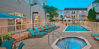 Outdoor pool with lounge chairs at Residence Inn Boston Tewksbury.
