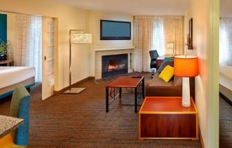 Spacious king room with TV and lounge at Residence Inn Boston Tewksbury.
