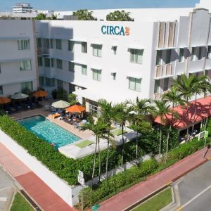 Pool area surrounded by pool chairs and greenery at Circa 39 Hotel.