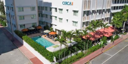 Pool area surrounded by pool chairs and greenery at Circa 39 Hotel.