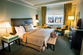 King bed with TV and work desk at Beacon Hotel.