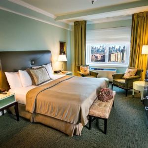 King bed with TV and work desk at Beacon Hotel.