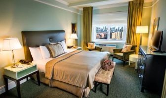 King bed with TV and work desk at Beacon Hotel.