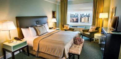 King bed with TV and work desk at Beacon Hotel.