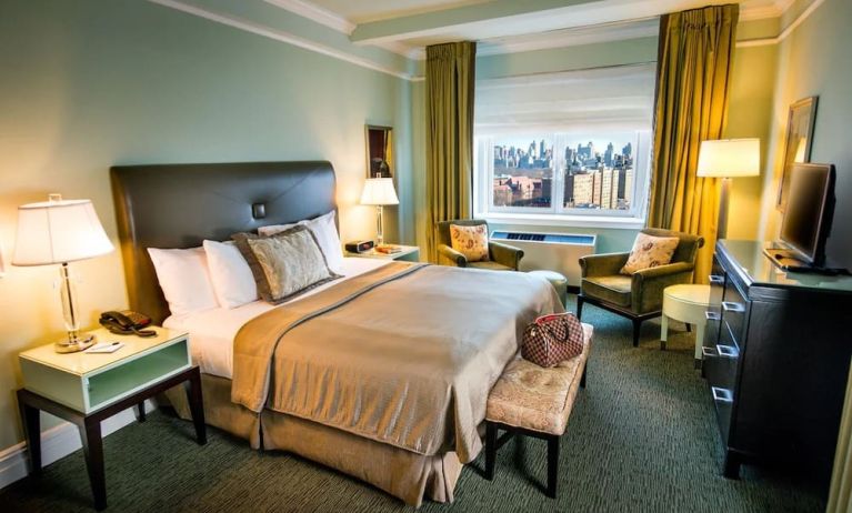 King bed with TV and work desk at Beacon Hotel.