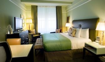 Delux king bed with TV and natural light at Beacon Hotel.