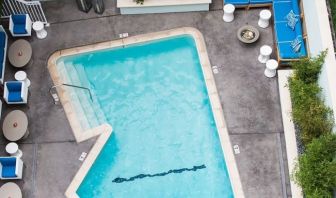 Refreshing outdoor pool surrounded by sun loungers at Maison 140 Beverly Hills.