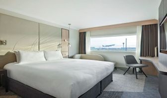 King bedroom with work desk and natural light at Hyatt Place London Heathrow Airport.