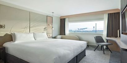 King bedroom with work desk and natural light at Hyatt Place London Heathrow Airport.