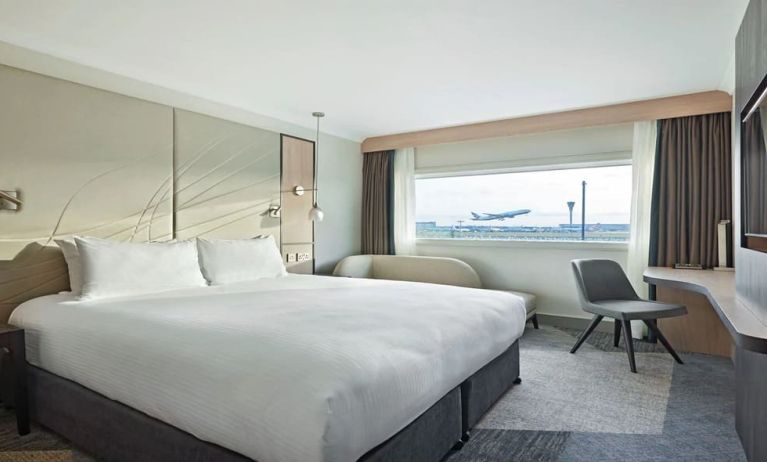 King bedroom with work desk and natural light at Hyatt Place London Heathrow Airport.