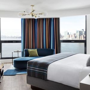 Spacious king bed with TV and seating area at Graduate New York.