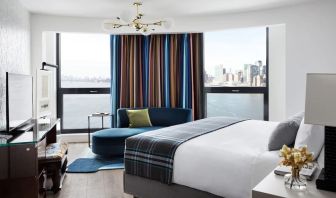 Spacious king bed with TV and seating area at Graduate New York.