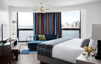 Spacious king bed with TV and seating area at Graduate New York.