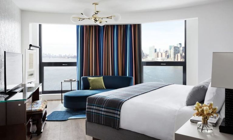 Spacious king bed with TV and seating area at Graduate New York.