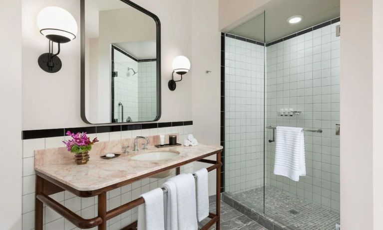 Private guest bathroom with shower at The Candler Hotel Atlanta, Curio Collection By Hilton.