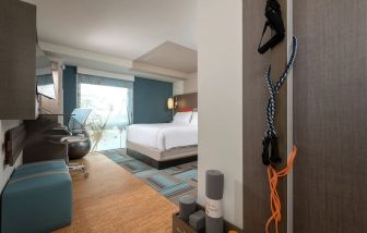 King bed with TV, desk, and natural light at Even Hotel Brooklyn.